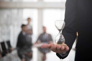 Personal Injury Attorneys in a Conference Room with One of them Holding an Hourglass