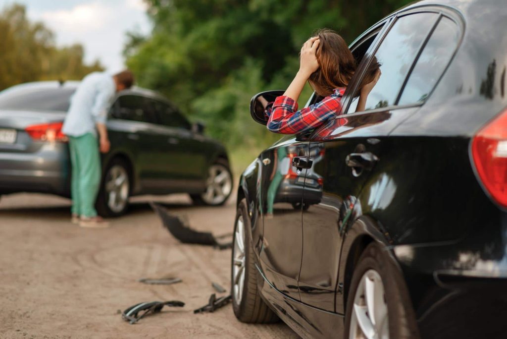 two drivers inspecting their vehicles after a car accident