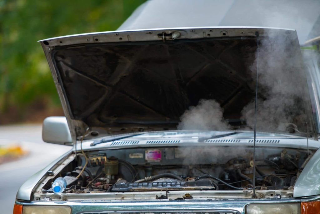 a car with an overheating engine and an open hood allowing smoke to escape