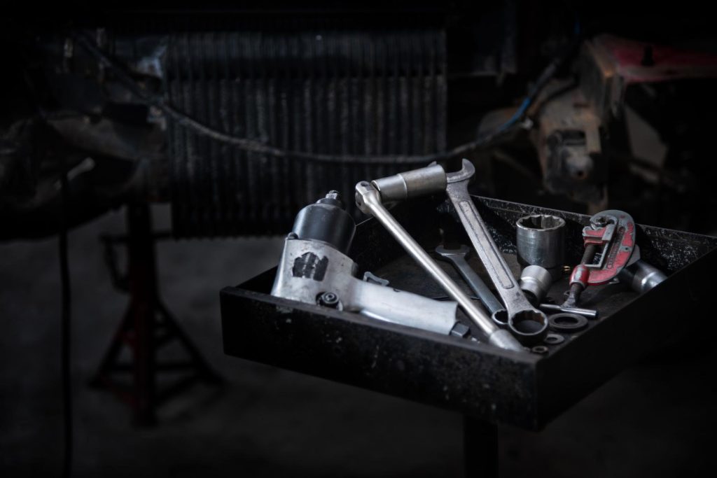 car maintenance tools on a tray in a garage