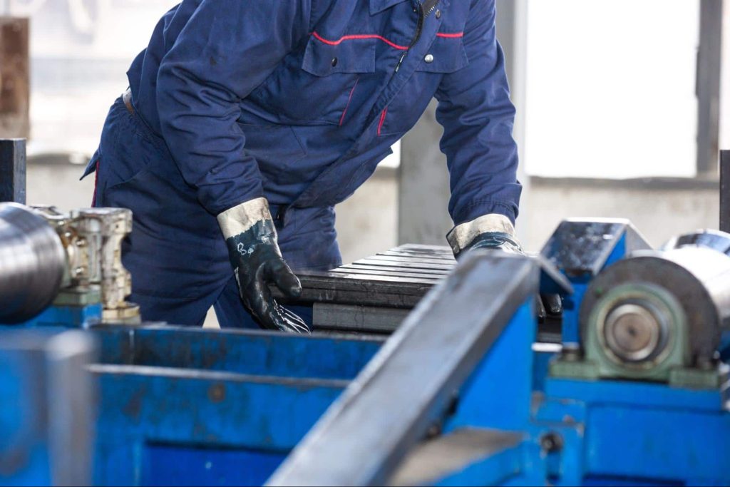 A factory worker sets up his machine at the beginning of his shift.