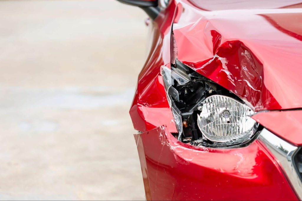 car with damaged headlight and fender Close up of a car with a damaged headlight and front fender. Damage from a car accident will diminish the value of a car even if it is repaired.