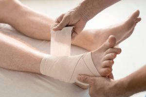 A doctor wrapping a patients foot after injury