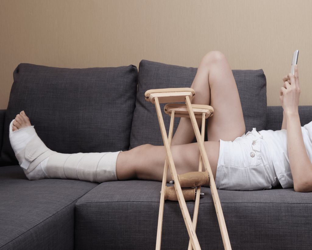 Woman laying out on couch with cast on leg