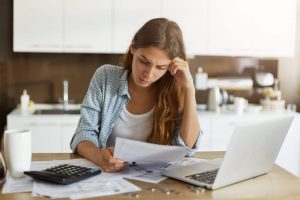 Young woman looking at bills.